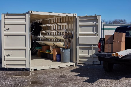 A shipping container with doors open showing tools, representing how shipping containers can be used to securely store tools, materials, and equipment to prevent theft and maintain organization.

