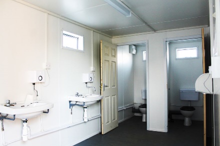 The interior view of a shipping container converted to a break room/restroom, to provide basic amenities for workers on-site.