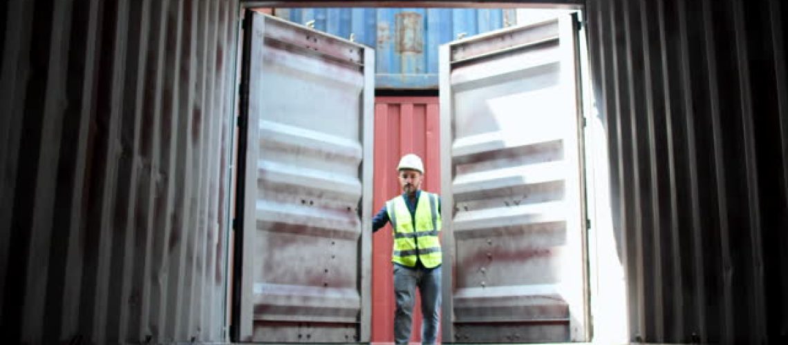 Dock worker opening a shipping container